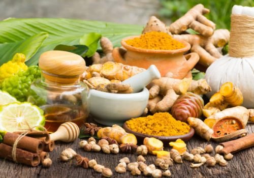 Turmeric powder,Turmeric in Mortar Grinder drugs and ingredient herbs on wooden background